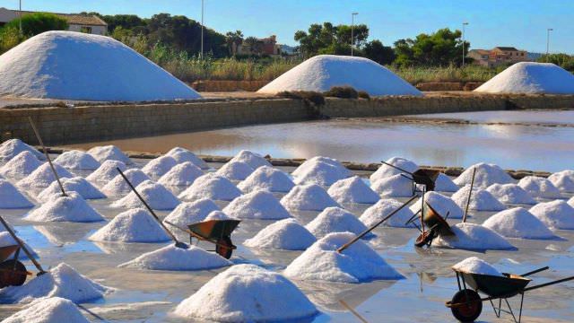 During the salt harvest season in Trapani, Sicily - The workers build these salt mounds completely by hand. 